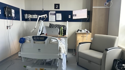 chambre d'hôpital avec un lit et un fauteuil.  