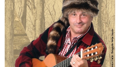 L'artiste habillé en chemise carreautée et chapeau de poil qui joue de la guitare L'artiste habillé en chemise carreautée et chapeau de poil qui joue de la guitare