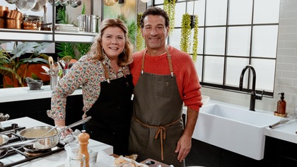 Marina et PAsquale posent en cuisine devant les fourneaux.