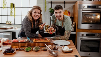 Marina et Camilo posent en cuisine avec le plat du jour.