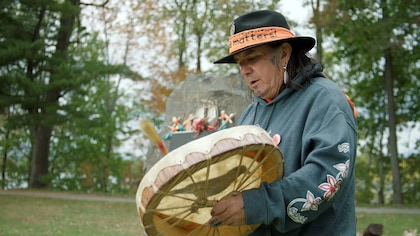 Un autochtone qui joue d'un instrument.