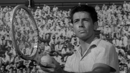 En noir et blanc, un homme s'apprête à servir au tennis. En noir et blanc, un homme s'apprête à servir au tennis.