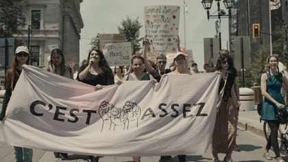 Des femmes qui manifestent avec une banderole portant l'inscription : C'est assez.