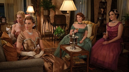 4 femmes dans des robes de soirée boivent du champagne au un salon.