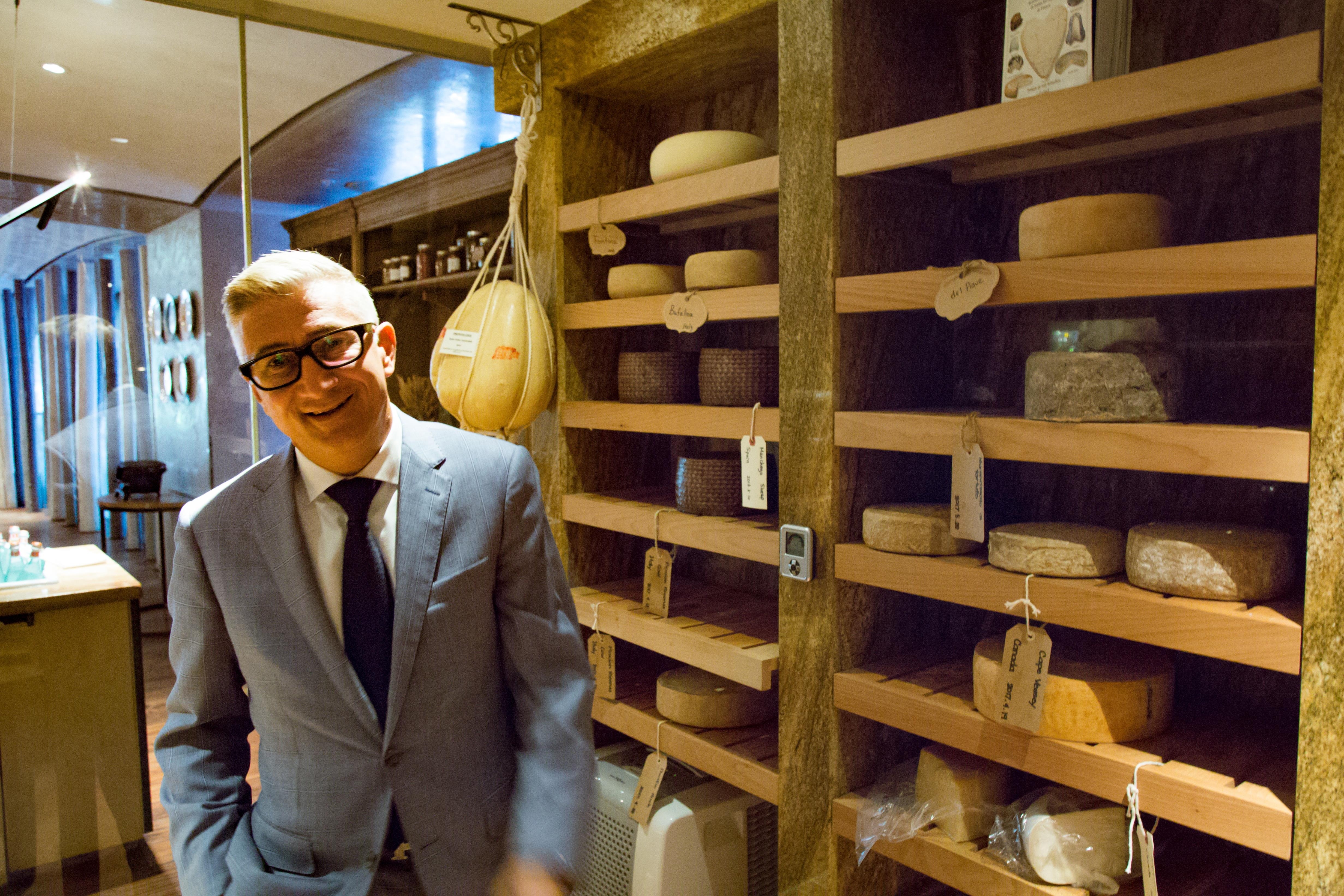 Un homme entouré de plusieurs fromages Un homme entouré de plusieurs fromages