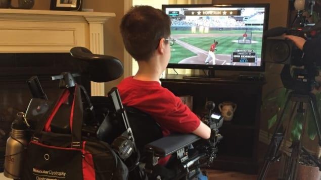 Noah Dugas se sert d'une manette adaptée pour jouer à des jeux vidéo. Noah Dugas se sert d'une manette adaptée pour jouer à des jeux vidéo.