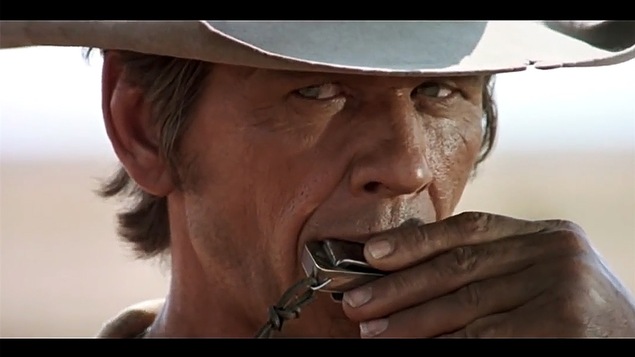 Charles Bronson jouant de l'harmonica dans le film <i>Il était une fois dans l'ouest</i>, de Sergio Leone. La musique du film, signée Ennio Morricone, a souvent été qualifiée de marquante.