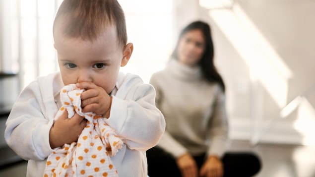 Un bébé semble sentir sa doudou pour se réconforter.