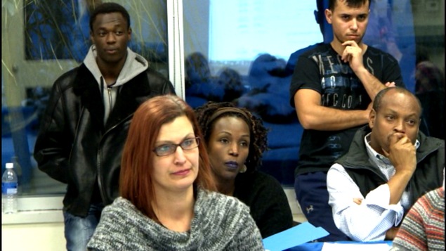 Des hommes et des femmes dans une réunion Des hommes et des femmes dans une réunion