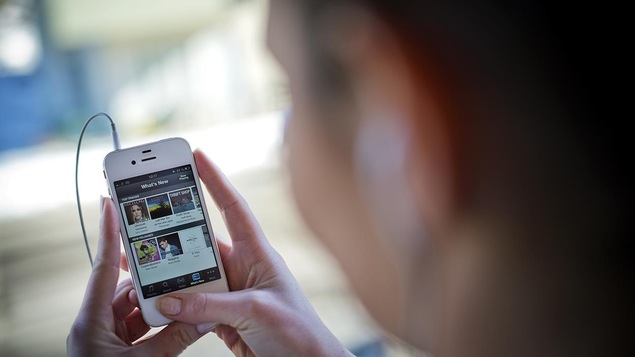Une femme écoute de la musique sur son téléphone intelligent Une femme écoute de la musique sur son téléphone intelligent