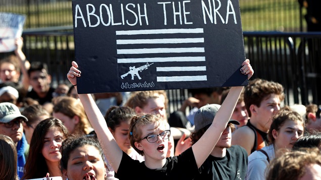 Une fille brandit une affiche qui demande l'abolition de la NRA.