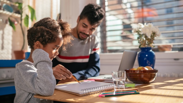 Un père aide sa fille avec ses devoirs