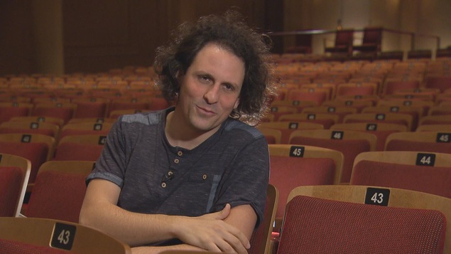 Alexandre Bloch est assis dans les sièges de l'opéra