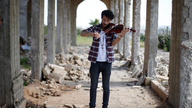 Le violoniste Ameen Mukdad, 28 ans, dans les ruines du sanctuaire de Nabi Yunus, dans l'est de Mossoul, en Irak. Le violoniste Ameen Mukdad, 28 ans, dans les ruines du sanctuaire de Nabi Yunus, dans l'est de Mossoul, en Irak.