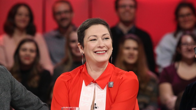 La femme vêtue de rouge sourit.
