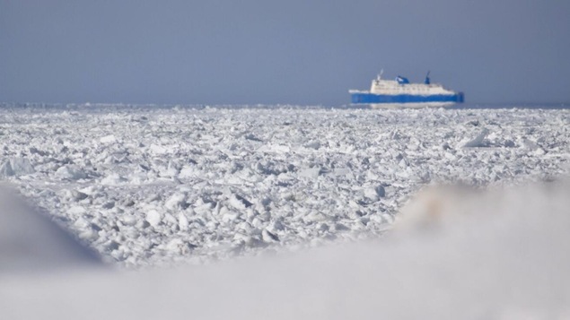 De la glace en avant-plan et le bateau à l'arrière.