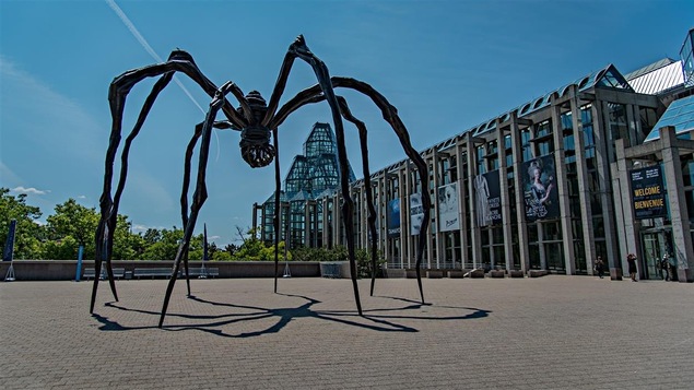 Une sculpture d'araignée en fer forgé devant un musée