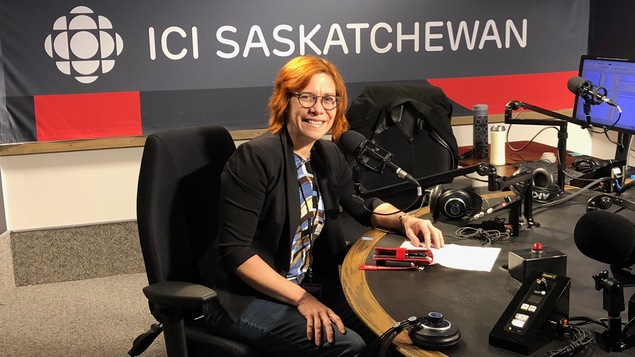 Une femme pose devant la caméra dans les studios de radio d'Ici Saskatchewan