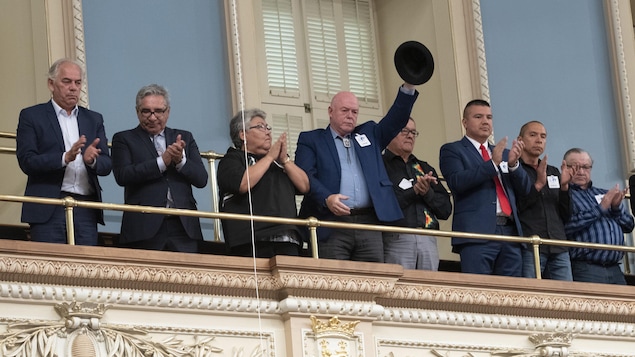 Le grand chef huron wendat Konrad Sioui lève son chapeau pendant que les députés de l'Assemblée nationale applaudissent après que le premier ministre du Québec, François Legault, se soit excusé auprès des dirigeants des Premières nations et des Inuits lors d'une déclaration à l'Assemblée législative à Québec, le mercredi 2 octobre 2019.