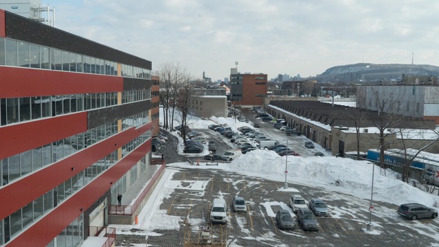 Une vue d'une partie d'un bâtiment avec le mont Royal à l'horizon.