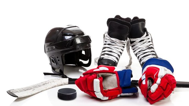 Un casque, des patins, un bâton, des gants et une rondelle de hockey.
