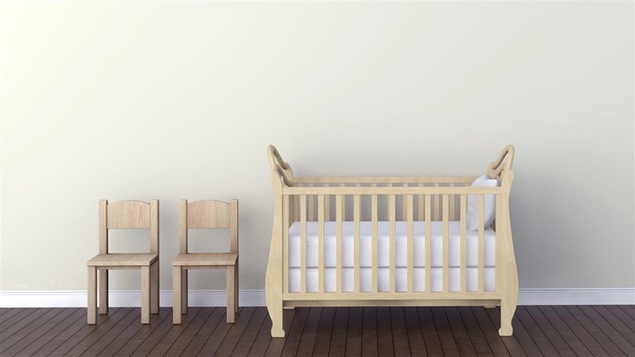 Un berceau et deux chaises posés dans une chambre Un berceau et deux chaises posés dans une chambre