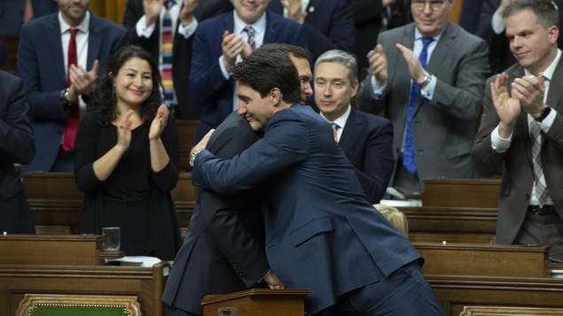Deux hommes se donnent une accolade.