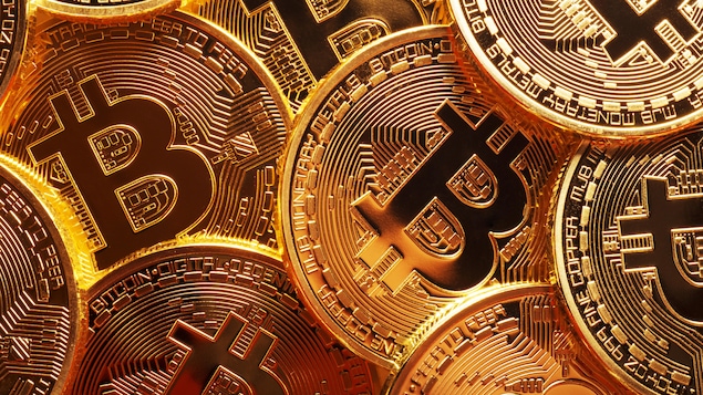 Une gros plan sur des pièces de monnaie dorées arborant le symbole de bitcoin. Une gros plan sur des pièces de monnaie dorées arborant le symbole de bitcoin.