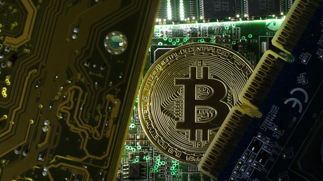 Une pièce de monnaie bitcoin parmi des cartes informatiques.
