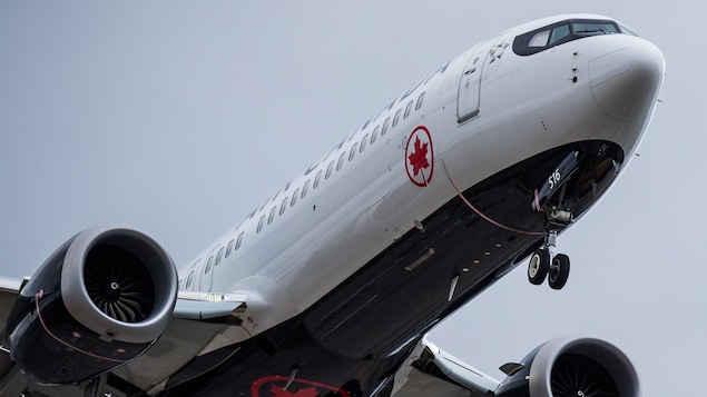 Un avion Boeing 737 Max de la compagnie Air Canada, pris en photo en contre-plongée alors qu'il décolle du tarmac.