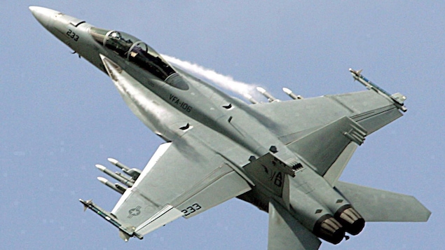 Un avion militaire gris qui vole dans un ciel bleu-gris. Un avion militaire gris qui vole dans un ciel bleu-gris.
