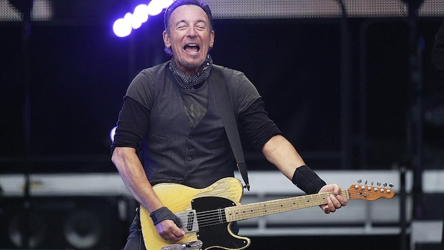 Bruce Springsteen joue de la guitare sur scène. Bruce Springsteen joue de la guitare sur scène.