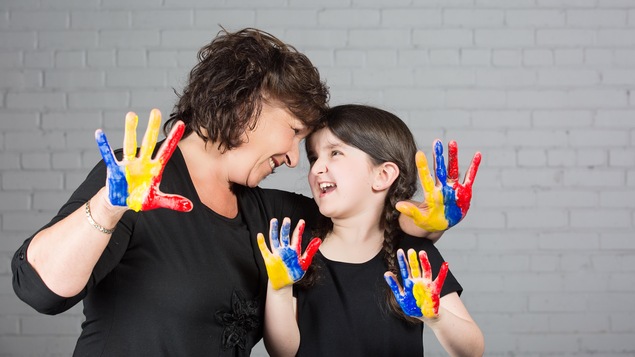 Elles se regardent et montrent leurs mains pleines de peinture. Elles se regardent et montrent leurs mains pleines de peinture.