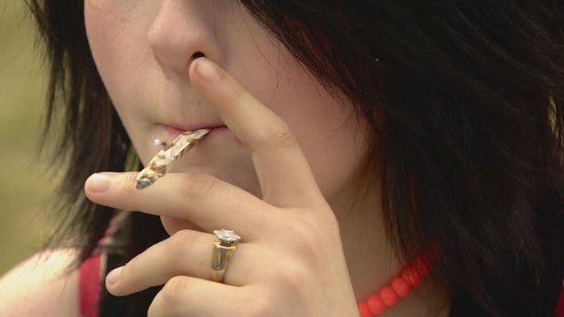 Une femme fume un joint au rassemblement du 4/20 à Edmonton. Une femme fume un joint au rassemblement du 4/20 à Edmonton.