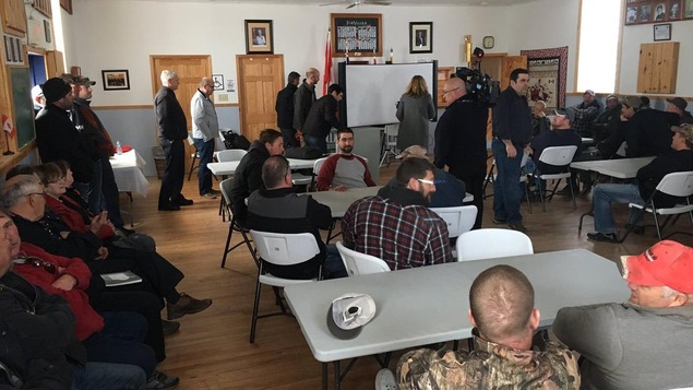 Des hommes assis dans une salle Des hommes assis dans une salle