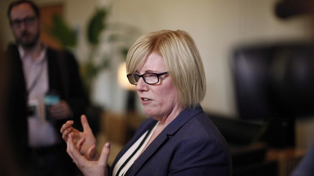 La ministre Qualtrough est une femme blonde, qui porte des lunettes aux montures noires, épaisses.