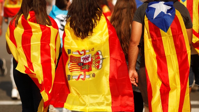 Des jeunes enveloppés dans des drapeaux catalan, espagnol et indépendantiste catalan, lors d'une manifestation à Barcelone, le 3 octobre.