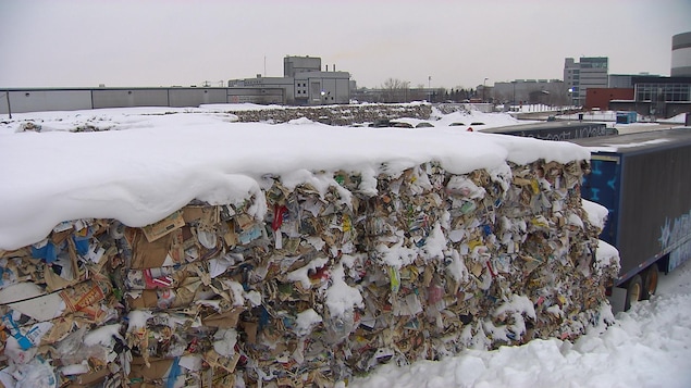 Des ballots de matières recyclables dans la neige, près du même centre, à Montréal, en janvier 2018 derrière des camions