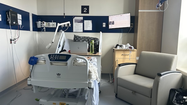chambre d'hôpital avec un lit et un fauteuil.  