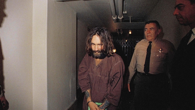 Charles Manson est escorté par un agent lors de son procès pour avoir ordonné sept meurtres, en 1969.