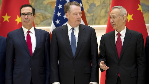 Des hommes politiques parlent devant des drapeaux américains et chinois.