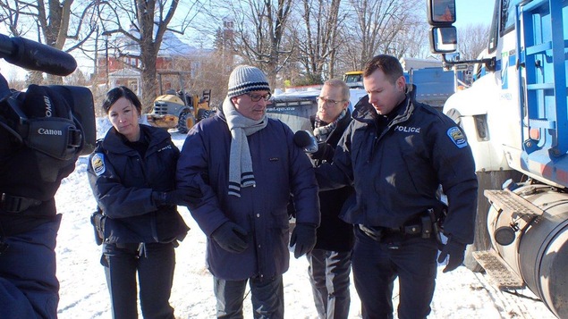 M. Picard, escorté par deux policiers de la RIPRSL.