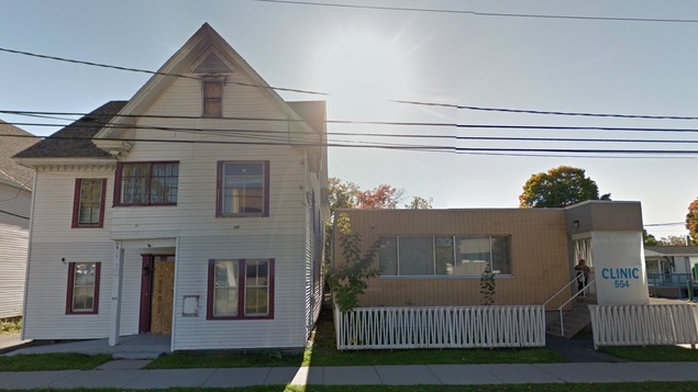 Une maison et un édifice commercial séparés par un mince espace Une maison et un édifice commercial séparés par un mince espace
