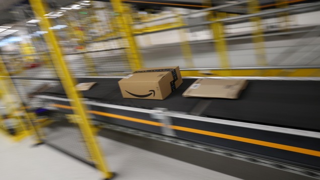 Un colis expédié par Amazon sur un tapis roulant.