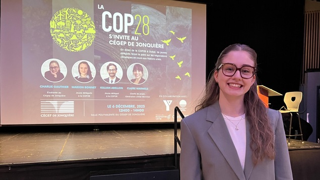 Charlie Gauthier étudiante au Cégep de Jonquière devant une affiche de la COP28