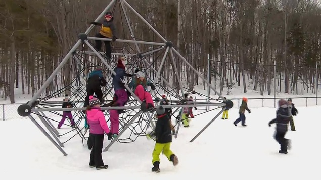 Des enfants en habit de neige jouent dans un module.