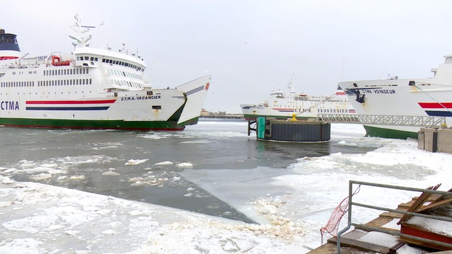 Trois navires dans un port de mer.