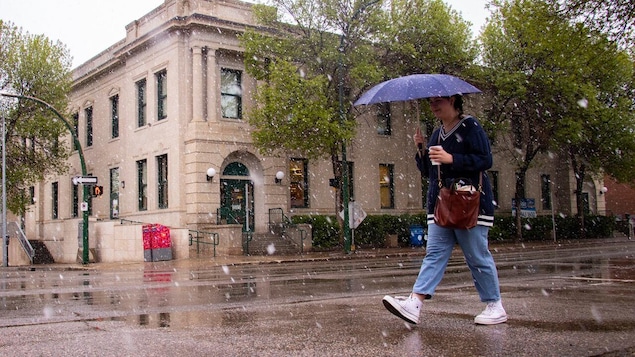 Une femme souriante marche avec un parapluie 