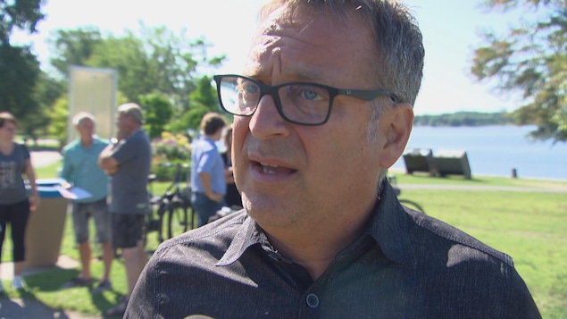 Daniel Champagne répond aux questions d'un journaliste à l'extérieur pendant l'été.
