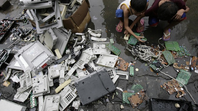 À Manille, des enfants recherchent des morceaux de cuivre parmi une pile de déchets électroniques. À Manille, des enfants recherchent des morceaux de cuivre parmi une pile de déchets électroniques.